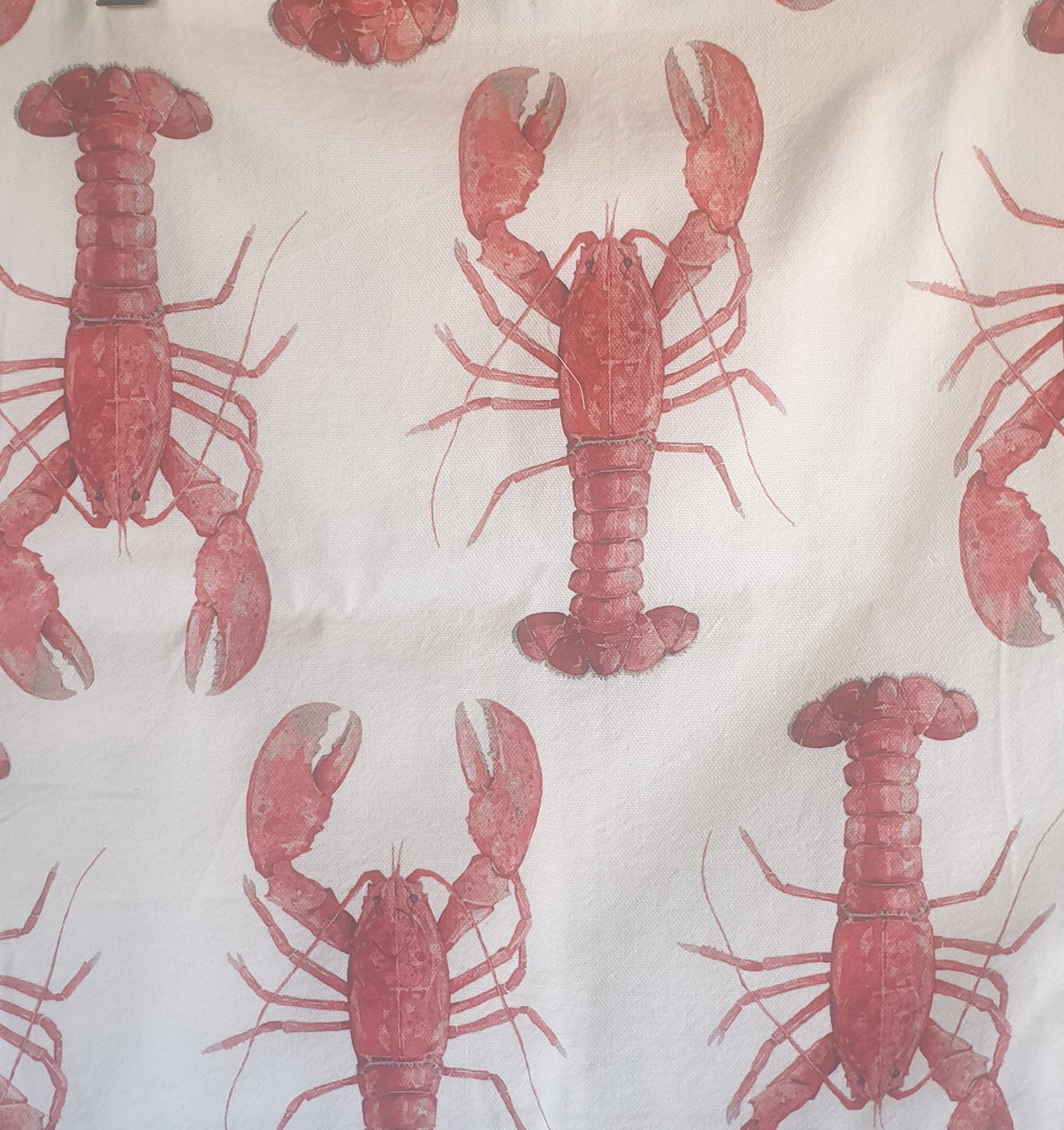 Close-up of red lobster fabric print on cream canvas